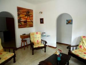 a living room with two chairs and a table at Chalets Anse Possession in Baie Sainte Anne