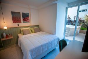 1 dormitorio con 1 cama y balcón con bañera en Apartamento Com Jacuzzi na Beira mar de João Pessoa no Branco Haus en João Pessoa