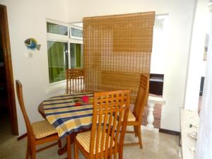 a dining room with a table and chairs and a window at Chalets Anse Possession in Baie Sainte Anne