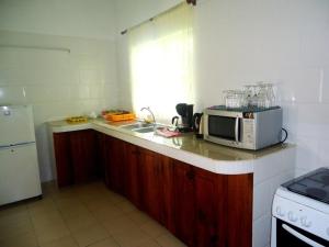 a kitchen with a microwave sitting on a counter at Chalets Anse Possession in Baie Sainte Anne