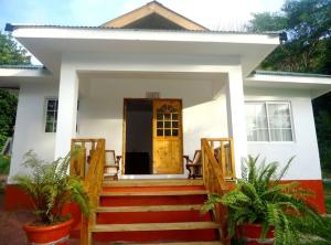 a house with a staircase leading to the front door at Chalets Anse Possession in Baie Sainte Anne
