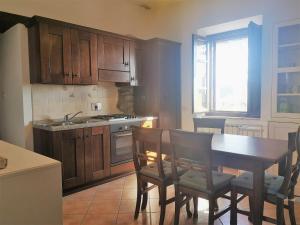 - une cuisine avec des placards en bois, une table et des chaises dans l'établissement Ryan Apartment, à Passignano sul Trasimeno