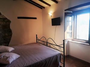 a bedroom with a bed and a window at Ryan Apartment in Passignano sul Trasimeno