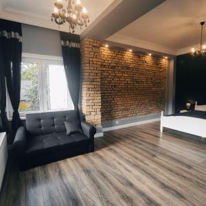 a living room with a couch and a brick wall at Apartament pod Karpaczem in Miłków