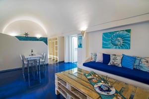 a living room with a blue couch and a table at Blue Dream - Santorini in Kamari