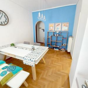 a dining room with a table and chairs and a clock at Noelli cozy and modern apartment in Athens