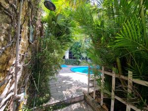un jardín con piscina y palmeras en Pousada Beijos y Abraços, en Natal