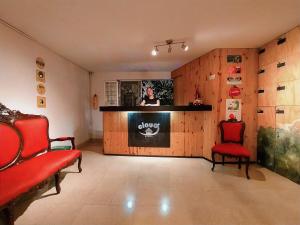 a living room with two red chairs and a fireplace at Cloud9 Hostel in Medellín