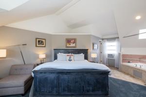 a bedroom with a large bed and a tub at Nantucket Whale Inn, Half Moon Bay in Half Moon Bay