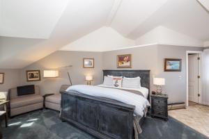 um quarto com uma cama grande e uma cadeira em Nantucket Whale Inn, Half Moon Bay em Half Moon Bay