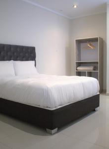 um quarto com uma cama grande e lençóis brancos em MUNAY TTIKA Hoteles em Moquegua