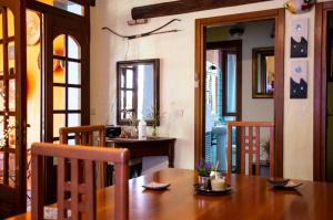 a dining room with a wooden table and some doors at B&B La Noria in San Sperate