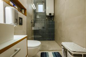 a small bathroom with a toilet and a shower at Green Duplex in Novi Sad +26 photos