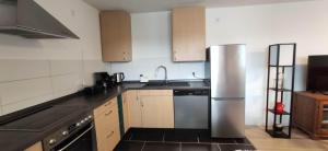 a kitchen with a stainless steel refrigerator and cabinets at Ferienwohnung Sonne in Beltheim