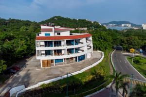 a building on a hill next to a road at LA LOMA SUITES in Ixtapa