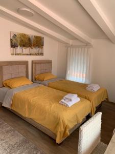 - 2 lits dans une chambre avec des draps jaunes dans l'établissement Centar Bruno, à Novi Pazar