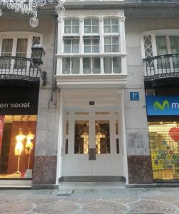 un edificio con una puerta y ventanas blancas en Casual Arriaga, en Bilbao