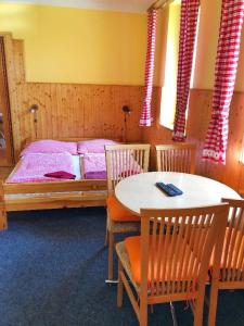 Schlafzimmer mit einem Bett, einem Tisch und Stühlen in der Unterkunft Apartmány U Švýcarského dvora in Janské Lázně