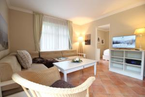 a living room with a couch and a table at Haus am Park Wohnung Nr1 in Spiekeroog