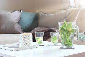 a table with four glass vases and a couch at Haus am Park Wohnung Nr1 in Spiekeroog