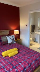a bedroom with a bed with a yellow blanket on it at Haste Ye Back in Inverness