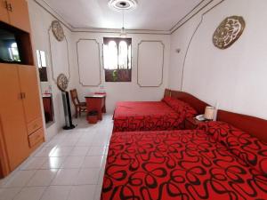 1 dormitorio con 2 camas y colcha roja en Casa de la Luna, en Ciudad de México