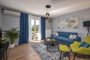 a living room with a blue couch and chairs at Blue Allure Apartment in Rijeka