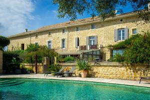 un edificio con piscina en frente de un edificio en Abacard Home Gite adult only, en Roquemaure