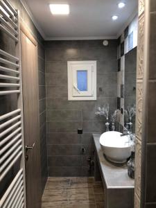 ein Badezimmer mit einem Waschbecken, einem Spiegel und einer Badewanne in der Unterkunft aspa2 in Platamonas