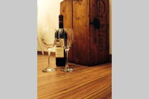 twee wijnglazen naast een fles wijn bij Valletta Timeless Elegance : City Centre Apartment in Valletta