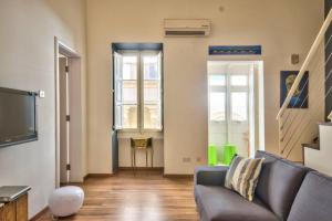 een woonkamer met een bank en een tv bij Valletta Timeless Elegance : City Centre Apartment in Valletta +6 foto's