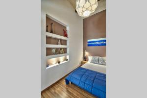 een slaapkamer met een blauw bed en planken bij Valletta Timeless Elegance : City Centre Apartment in Valletta