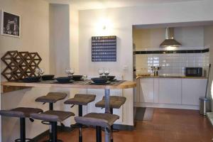 una cucina con bancone e sgabelli di CENTRE VILLE Appartement 75m2, avec 3 chambres a Carcassonne Altre 6 foto