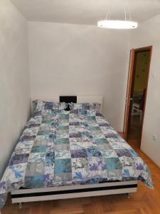 Un dormitorio con una cama con una colcha encima en Milgor, en Banja Luka