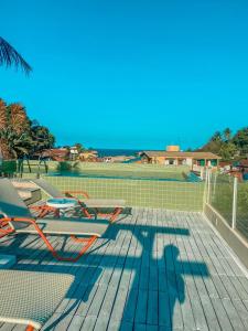莫羅聖保羅的住宿－陽光阿爾特斯波薩達精品酒店，一个带椅子的甲板和网球场
