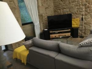 salon z kanapą i telewizorem z płaskim ekranem w obiekcie Casa Nicolás w mieście Bretal