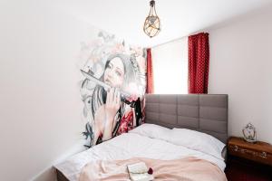 a bedroom with a bed with a painting on the wall at Petra Inn Apartments in historical palace Bratislava in Bratislava