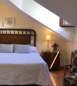- une chambre avec un grand lit et une chaise dans l'établissement Casa Rural Maria, à Molinaseca
