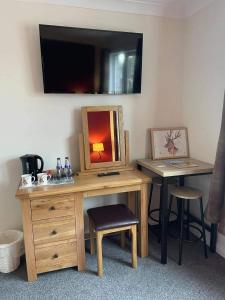 a wooden desk with a mirror and a table with a stool at Haste Ye Back in Inverness