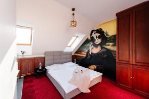 a bedroom with a bed with a painting of a woman at Petra Inn Apartments in historical palace Bratislava in Bratislava