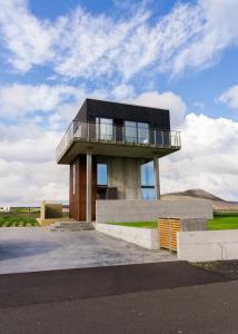 een gebouw met een balkon erboven bij Converted Water Tower in Grindavík