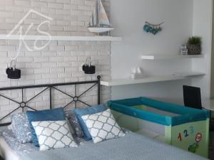 sypialnia z łóżkiem z niebiesko-białymi poduszkami w obiekcie Amko Style Apartament Pod Aniołami 59 Willa Nord w Jastrzębiej Górze