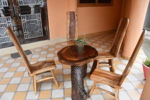 a table and two chairs and a table with a plant on it at Odo So Royal Hotel in Oko Sombo +21 photos