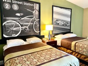 a hotel room with two beds and a bike on the wall at Super 8 by Wyndham Rocky Mount I-95 EXIT 145 in Battleboro