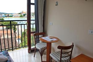 a table and two chairs in a room with a balcony at Pousada Solar Do Triunfo in Triunfo