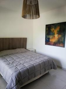 1 dormitorio con 1 cama y una pintura en la pared en Disfruta como local II (dpto) en 