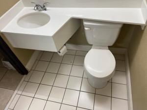 a bathroom with a white toilet and a sink at Super 8 by Wyndham Rocky Mount I-95 EXIT 145 in Battleboro +30 photos
