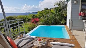 a swimming pool on a balcony with a view of the ocean at Blue Haven Villa 2 in Bouillante
