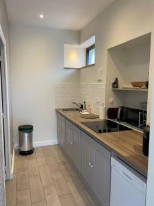 uma cozinha com um lavatório e uma bancada em Maison La Tour em Dinan
