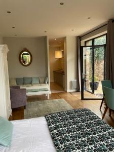 a bedroom with a bed and a couch and a mirror at Maison La Tour in Dinan